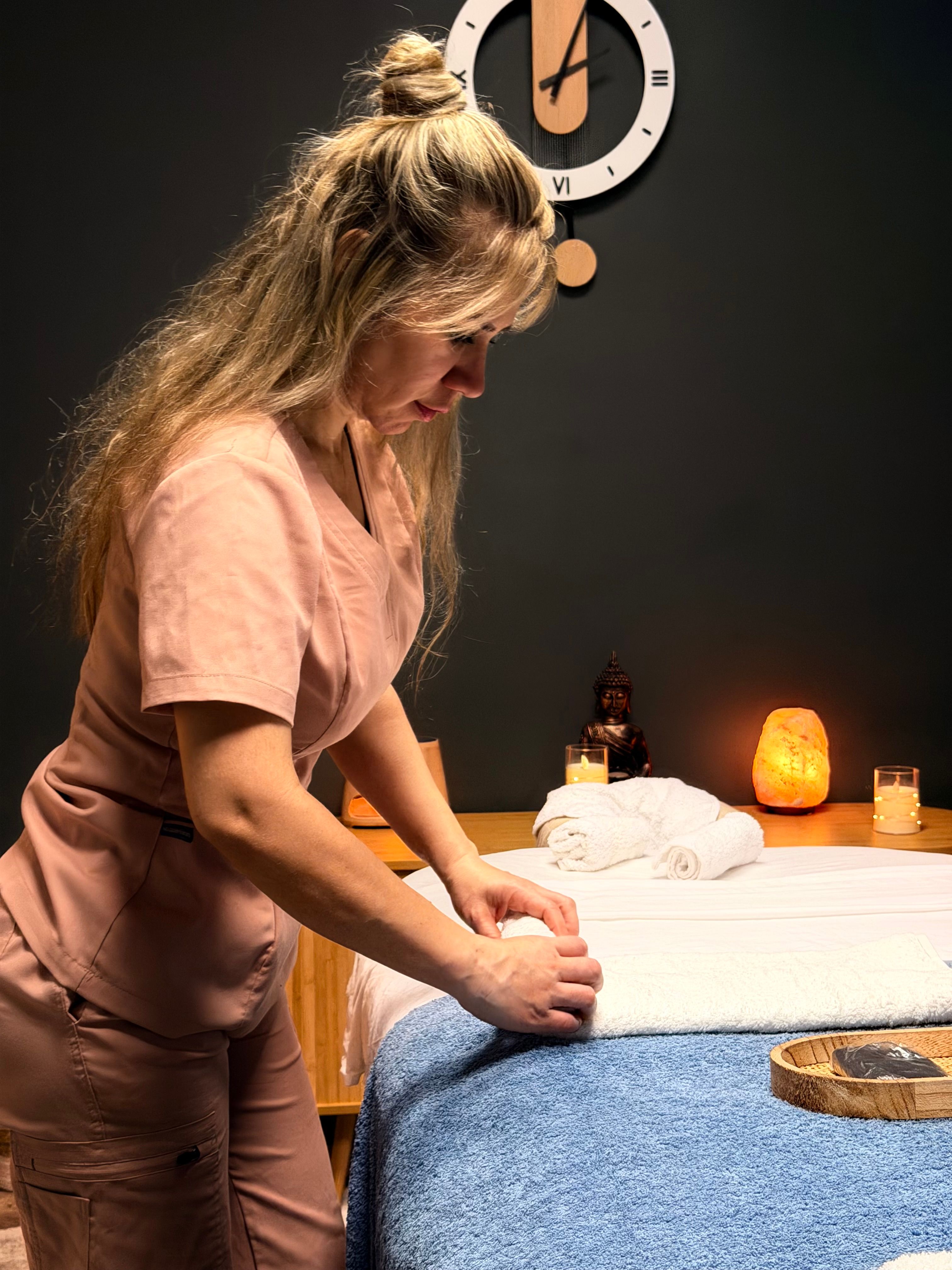 Adriana preparando la camilla con toallas limpias antes de una sesión